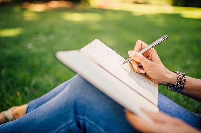 writing in a journal on the lawn